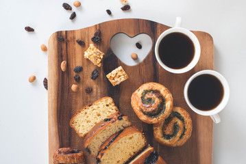 Two cup of coffee with sweet bread on the wooden table