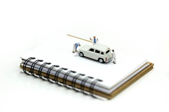 Miniature people : Professional painting car in a paint chamber during.