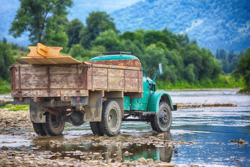 Obraz premium old truck transports cargo wade across the river.