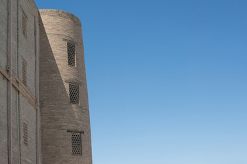 An old brick building with a tower. Ancient buildings of medieval Asia. Bukhara, Uzbekistan