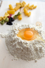 Paste theme. Different kinds of pasta on a wooden background. Farfalle, fettuccine, noodles, fusilli and penne rigate