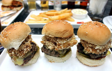 Cheeseburger sliders with onion rings and sesame seed buns