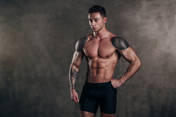 Fototapeta na wymiar Studio Shot of a Stunning Hot Sporty Body of a Fitness Man with Perfect Forms
