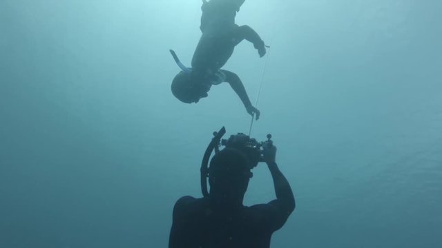 Set of two underwater clips about freediving. Underwater operator films a movie of the freediver gliding along a rope. Second clip is the result of filming.
