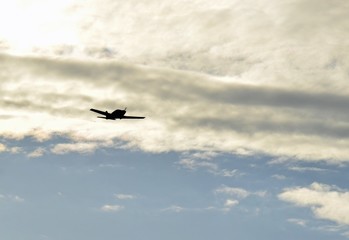 single engine low wing  propeller airplane silhouette flying in the evening sky 