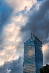Fototapeta na wymiar Modern glass office building against dramatic blue and yellow sky.