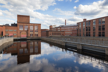 Old red brick industrial buildings along the Tammerkoski rapids in downtown Tampere, Finland on a sunny day. © tuomaslehtinen