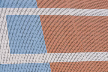 Blue and orange brick wall with white lines. Background of wall modern building close-up.