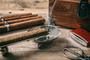 Cuban cigar in an ashtray on wooden background