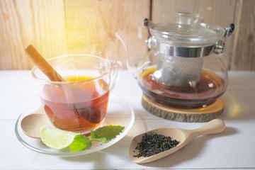 Tea in a glass cup, mint leaves, dried tea, sliced lime Cinnamon stick
