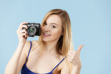 Blonde woman with camera on blue