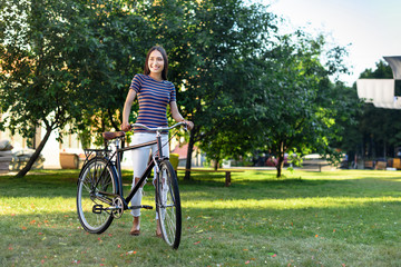 young asian woman with retro bicycle in park