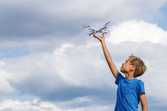 Child holding drone outdoors at summer day