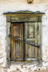 Vintage background from fragment of an old adobe wall with wooden green window