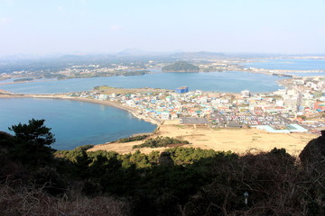 Fototapeta na wymiar Cityscape and blue sea view from Seongsan Ilchulbong in Jeju island, South Korea