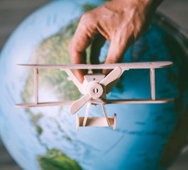 Wooden model vintage airplane fly  near the Earth globe