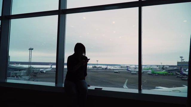 woman in airport terminal waiting for flight
