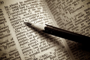 Black pencil point on creative word on old dictionary