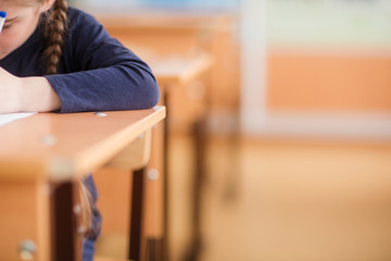 school class background. student writes in a notebook with his left hand