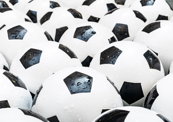 Many black and white soccer balls background. Football balls in a water