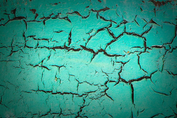 Vintage background of an old cracked wall painted in turquoise color