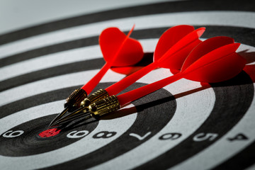 dart arrow hitting in the target center of dartboard. concept of the success