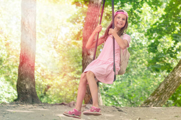 Cute little girl having fun on a swing