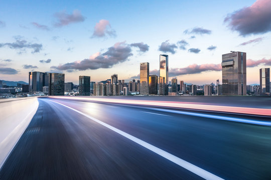 asphalt road with city skyline
