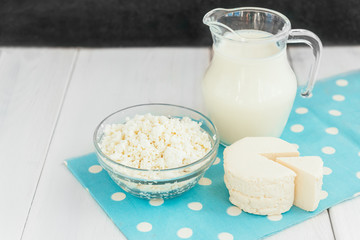 Dairy products. Milk, cottage cheese and cheese on white wooden background.