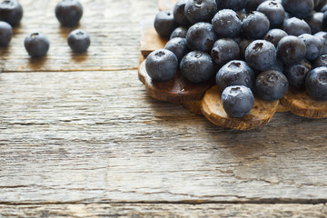 Blueberries on old wooden dishes, space for text