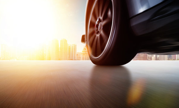 Low Angle Side View Of Car Driving Fast At Sunset With Motion Speed Effect .