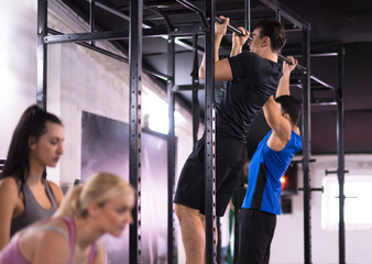 young athletes doing pull ups on the horizontal bar