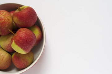 A close-up shot of some red apples on a bowl isolated on a white background