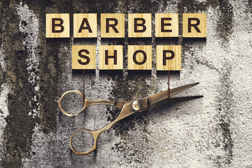 Concept Barber Shop. An inscription on wooden cubes against the background of an old vintage wall.