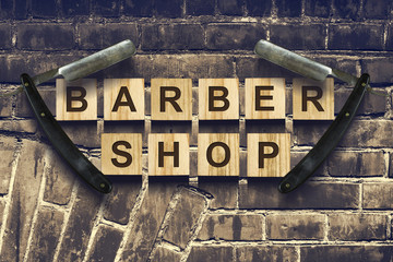 Concept Barber Shop. An inscription on wooden cubes against the background of an old vintage wall.