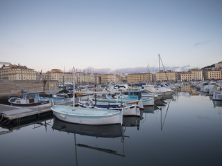 Fototapeta na wymiar marseille, france, 4 june 2018: many fishing boats and yaughts in old harbor of french city marseille at dusk