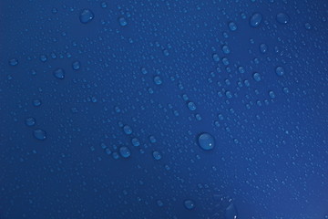 Water drops on flat blue surface