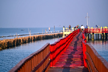 Obraz premium People come to watching dolphin at wooden red bridge, Gulf of Thailand, near by Tha Chin estuary, Samutsakhon province, Thailand