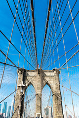 Brooklyn bridge over water, blue sky with sunshine