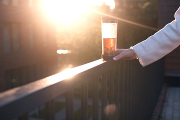 close up woman hand on sunset with cup of tea, copyspace