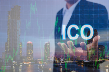 Fototapeta na wymiar Double exposure of businessman holding text ico on hand and defocused chart background with modern city background. Virtual cryptocurrency concept. Digital money, exchange, ico