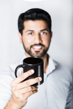 Arabic man in shirt with cup of coffee or tea