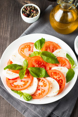 Close-up photo of caprese salad with ripe tomatoes, basil, buffalo mozzarella cheese. Italian and Mediterranean food concept. Fresh and healthy organic meal. Starter and antipasti. 