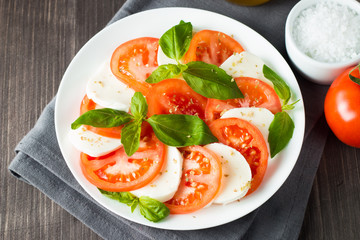 Close-up photo of caprese salad with ripe tomatoes, basil, buffalo mozzarella cheese. Italian and Mediterranean food concept. Fresh and healthy organic meal. Starter and antipasti. 