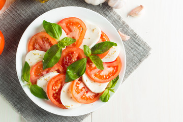 Close-up photo of caprese salad with ripe tomatoes, basil, buffalo mozzarella cheese. Italian and Mediterranean food concept. Fresh and healthy organic meal. Starter and antipasti. 