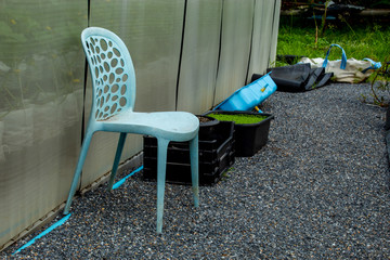 Plastic chair blue on the small stones in garden.