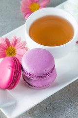 Photo of cake macarons, gift box, tea, coffee, cappuccino and flowers. Sweet romantic food macaroon concept. Morning breakfast and presents. Valentine's day concept.