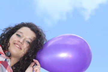 Fototapeta premium Young woman with a balloon on the blue sky background