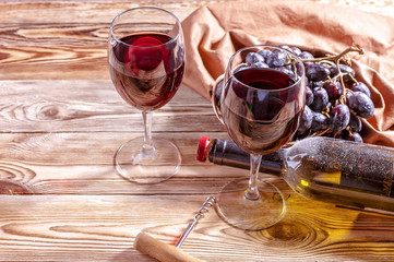 Red wine and red grapes on a wooden background.