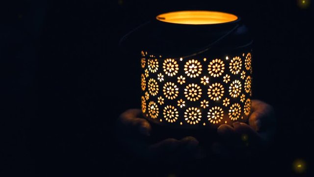 Cinemagraph - Female hands hold lantern  with magical lights of fireflies at night  . Concept of romance. Motion Photo.